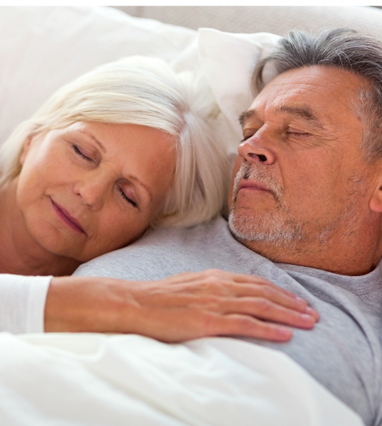 Senior man and woman sleeping soundly after treating obstructive sleep apnea in Scottsdale