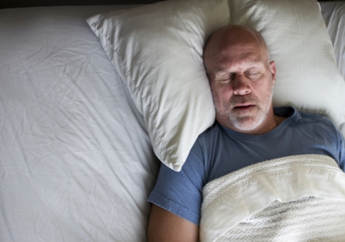 Older man sleeping on his back with mouth open